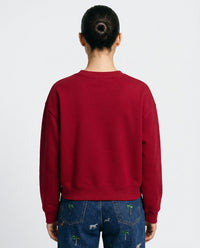 Back angle of model wearing red Saint Teddy Bear Sweatshirt showing relaxed oversized fit