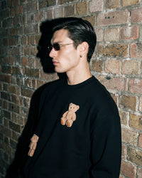 Model wearing black Saint Teddy Bear Sweatshirt showing full streetwear styling