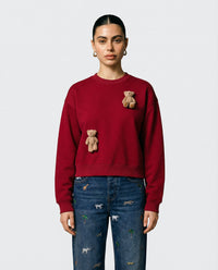 Lifestyle close-up of red Saint Teddy Bear Sweatshirt showing plush bears and fabric texture