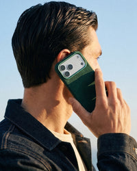 Man holding STICKYZOO Evergreen Alcantara phone case during a call, soft suede texture in natural light