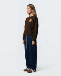 Lifestyle shot of STICKYZOO Saint Teddy Bear Sweatshirt in dark brown showing everyday styling