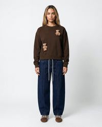 Model wearing STICKYZOO Saint Teddy Bear Sweatshirt in dark brown showing boxy silhouette and tonal plush detail
