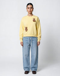 Model wearing STICKYZOO Saint Teddy Bear Sweatshirt in lemon showing relaxed proportions