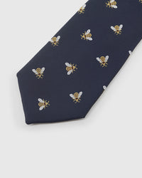 Embroidered, not printed STICKYZOO Honeybee Tie flat blade showing repeating bee motifs in gold and white thread on navy mulberry silk