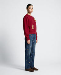 Side view of red Saint Teddy Bear Sweatshirt showing dropped shoulders and streetwear proportions