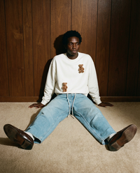 Lifestyle shot of model wearing STICKYZOO Saint Teddy Bear Sweatshirt in white