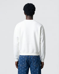 Model in white Saint Teddy Bear Sweatshirt showing fit from alternative angle
